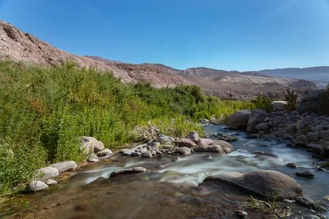 Silk effect on river with vegetation and mountains on the background Stock Photos