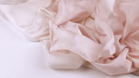 A silk fabric or handkerchief falls onto a white background in slow motion. Video stock 337403122