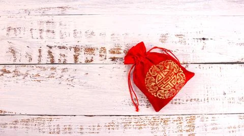 Silk red pouch with gold pattern on white boards Stock Photos