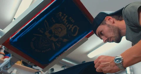 Silk screen printing process - making a print on a t-shirt. 4K UHD Stock Footage 95349484