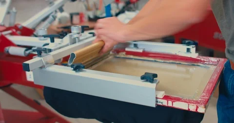 Silk screen printing process - making a print on a t-shirt. 4K UHD Stock Footage 95393555