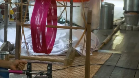 Silk spinning process at silk factory, Chiang Mai, Thailand. Woman spun red dyed Stock Footage 315850933