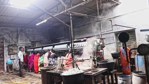 Silk worker boiling silkworm cocoons for thread extraction in a traditional 库存影片 340412125