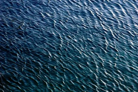 The silky blue surface of the deep sea with the reflection of light on the wa Stock Photos