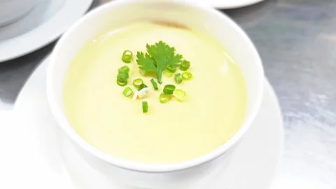 Silky smooth steamed egg custard garnished with scallions and coriander. Stock Footage 342393724