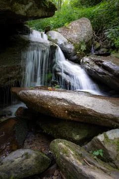 Silky water tumbles over large rocks amid lush foliage in  North Carolina, US Foto stock