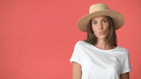 Silly and flirty good-looking brunette woman in white t-shirt, straw hat enjoy Stock Footage 115648385
