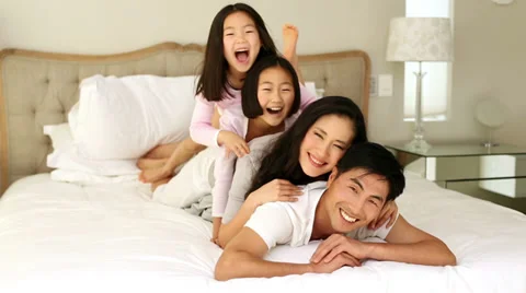 Silly family playing on the bed Stock Footage 32880841
