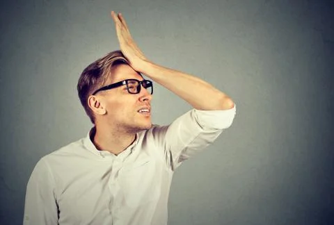 Silly man slapping hand on head having duh moment Stock Photos