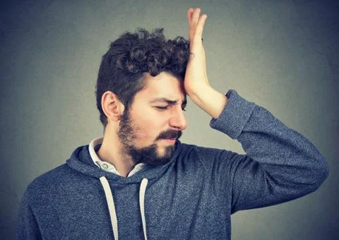Silly young man, slapping hand on head having a duh moment Stock Photos