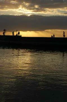 Silouhette on a pier in sunset Stock Photos