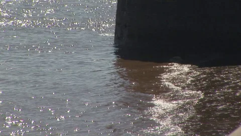 Silted glittering waves hitting a dock post on the river Humber. Hull, UK Stock Footage 103290564