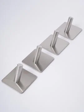 Silver adhesive wall hooks row angled Stock Photos