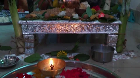 Silver altar table holding a copper kalash with coconut over wheat grains, betel Stock Footage 346017848