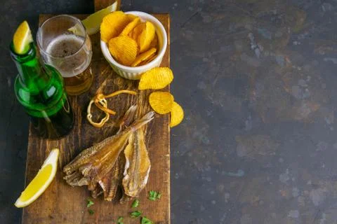 Silver Amber Fish with pepper with beer, lemon and potato chips on dark woode Stock Photos