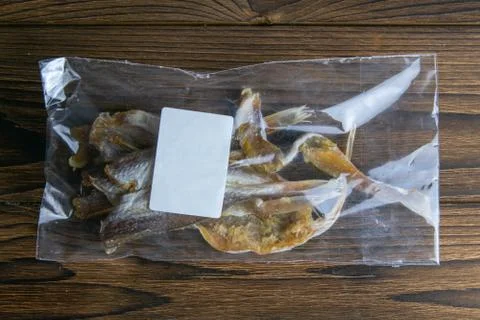 Silver Amber Fish with pepper in a transparent package whith white label appe Stock Photos