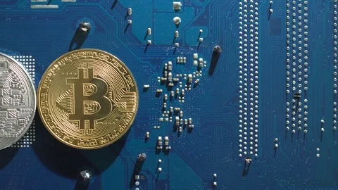 Silver and Gold Bitcoins virtual currency on a circuit board background Stock Footage