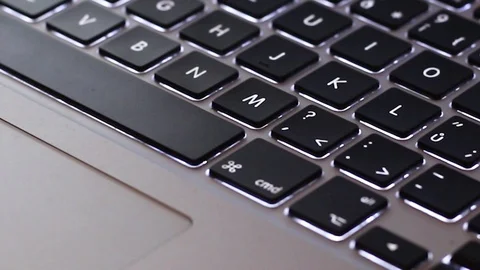 Silver backlit computer keyboard with black key and touchpad - zooming in. Stock Footage 103060762