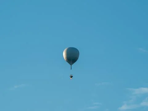 Silver balloon floats high in clear blue sky Photos