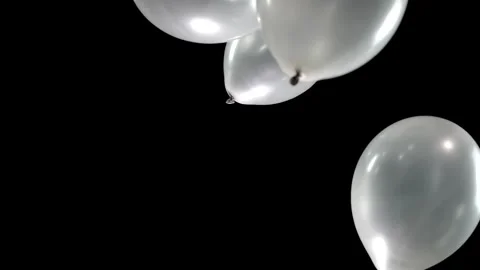 Silver Balloons Float Gracefully in Slow Motion, Their Shiny Surfaces Glowing Stock Footage 303416976