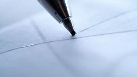A silver ballpoint pen tip touching down on white paper ruled with a grid. Stock Footage 321213896