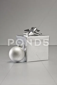 Silver bauble and present Stock Photos