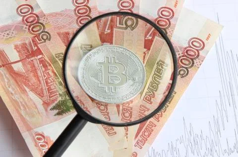 Silver bitcoin on the background of Russian banknotes Stock Photos