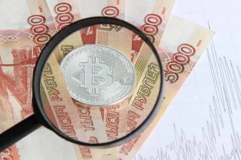 Silver bitcoin on the background of Russian banknotes Stock Photos