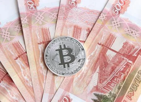Silver bitcoin on the background of Russian banknotes Stock Photos