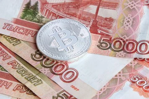 Silver bitcoin on the background of Russian banknotes Stock Photos