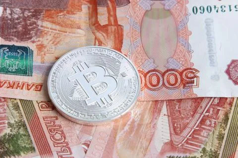 Silver bitcoin on the background of Russian banknotes Stock Photos