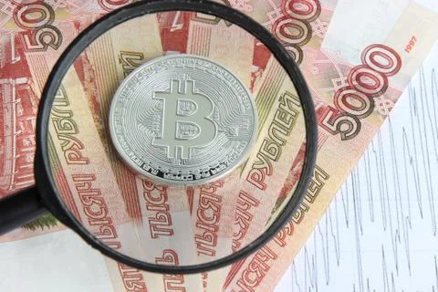 Silver bitcoin on the background of Russian banknotes Stock Photos