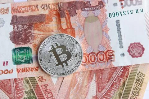 Silver bitcoin on the background of Russian banknotes Stock Photos