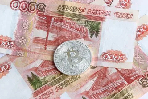 Silver bitcoin on the background of Russian banknotes Stock Photos