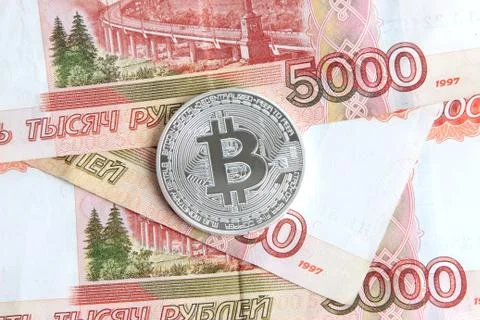 Silver bitcoin on the background of Russian banknotes Stock Photos