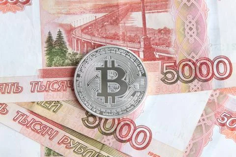 Silver bitcoin on the background of Russian banknotes Stock Photos