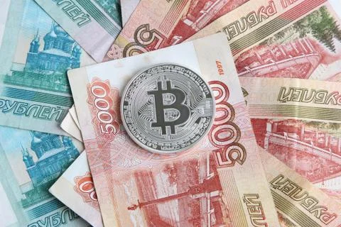 Silver bitcoin on the background of Russian banknotes Stock Photos