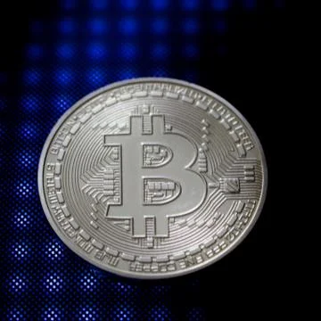 Silver bitcoin coin on a blue pattern Stock Photos