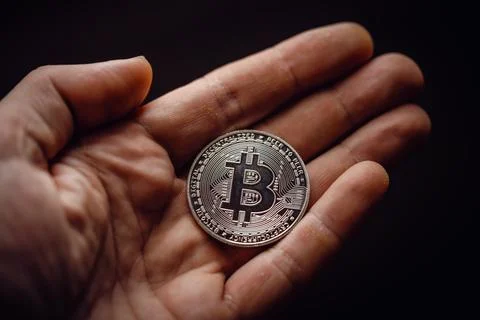 Silver bitcoin cryptocurrency in a hand Stock Photos