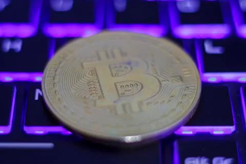 Silver bitcoin on illuminated computer keyboard Stock Photos