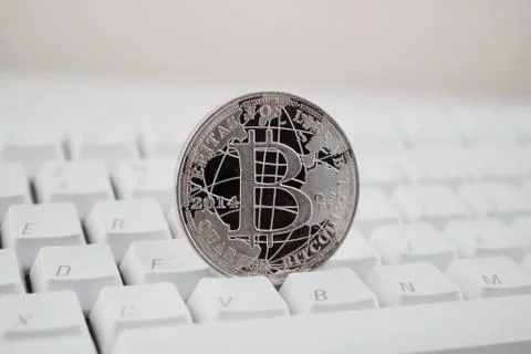Silver bitcoin on the keyboard Stock Photos