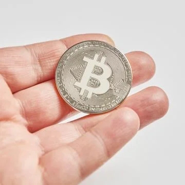 Silver Bitcoin in a man's hand Stock Photos