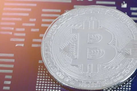 Silver bitcoin placed on a computer of hardware mainboard. Stock-Fotos