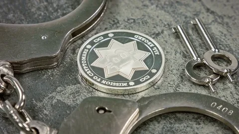 Silver bitcoin surrounded by handcuffs. Closeup rotation. illegal cripto concept Video stock 79192300