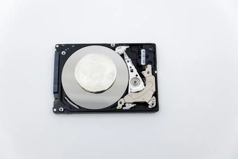 Silver bitcoin token on top of an open hard drive.Worldwide virtual internet  Stock Photos
