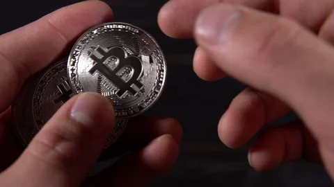 Silver bitcoins holding in hand Stock Footage 87212442
