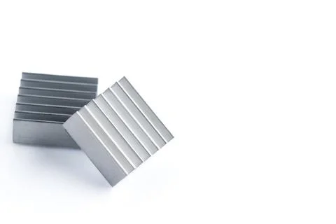 Silver blocks with parallel grooves rest on white Stock Photos
