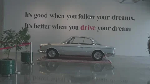 Silver BMW e9 coupe displayed on a red Persian carpet inside a modern Stock Footage 308924360