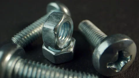 Silver bolts and nuts close-up on a dark background spin with iridescent Stock Footage 170565526