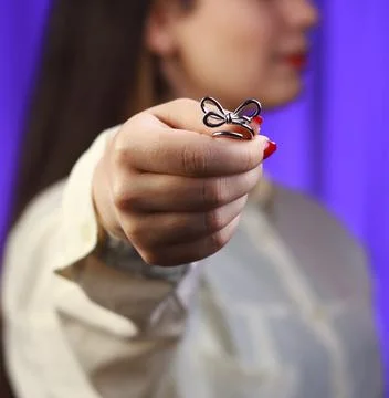 Silver bow ring held in hand, macro fashion jewelry product with minimal styling Stock Photos